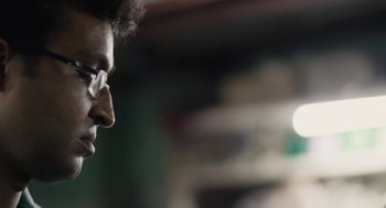 Movie still from “All That Breathes” (2022), directed by Shaunak Sen – A person wearing glasses; Close Up shot, Low angle