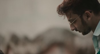 Movie still from “All That Breathes” (2022), directed by Shaunak Sen – A person wearing glasses; Close Up shot, Low angle
