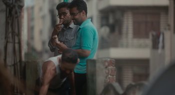 Movie still from “All That Breathes” (2022), directed by Shaunak Sen – A couple of men standing next to each other on a street; Medium shot, High angle