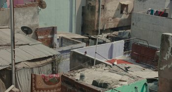 Movie still from “All That Breathes” (2022), directed by Shaunak Sen – An aerial view of an urban area with buildings; Extreme Wide shot, High angle