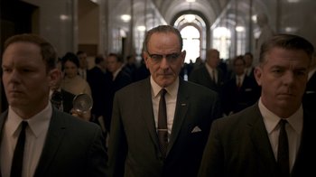 Movie still from “All the Way” (2016), directed by Jay Roach – An older man in a suit and tie in front of a group of people; Medium shot, Low angle