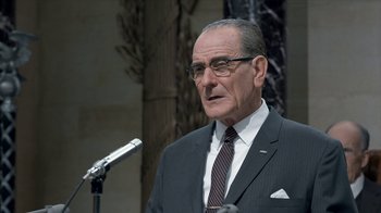 Movie still from “All the Way” (2016), directed by Jay Roach – An older man wearing a suit and tie; Close Up shot, Over the shoulder angle