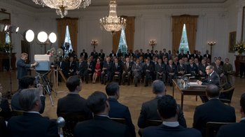 Movie still from “All the Way” (2016), directed by Jay Roach – A group of people sitting in front of a microphone; Wide shot, High angle