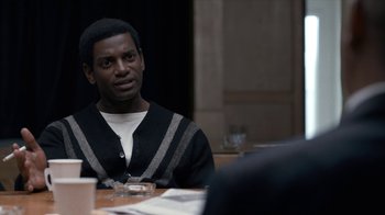 Movie still from “All the Way” (2016), directed by Jay Roach – A man sitting at a table with a drink in front of him; Medium shot, Over the shoulder angle