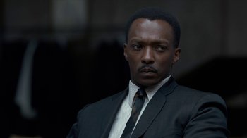 Movie still from “All the Way” (2016), directed by Jay Roach – A man wearing a suit and tie in front of a building; Close Up shot, Over the shoulder angle