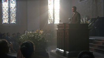 Movie still from “All the Way” (2016), directed by Jay Roach – A man in a suit is giving a sermon in a church; Wide shot, Low angle