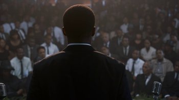 Movie still from “All the Way” (2016), directed by Jay Roach – A man standing in front of a crowd; Medium shot, Over the shoulder angle