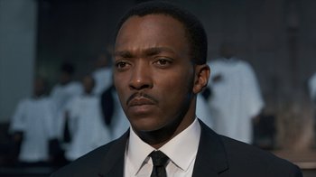 Movie still from “All the Way” (2016), directed by Jay Roach – A man wearing a suit and tie in front of a group of people; Close Up shot, Low angle