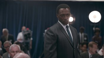Movie still from “All the Way” (2016), directed by Jay Roach – A man wearing a suit and tie in front of a camera; Close Up shot, Over the shoulder angle