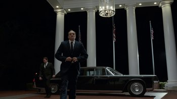 Movie still from “All the Way” (2016), directed by Jay Roach – A man in a suit and tie standing in front of a car; Wide shot, Low angle