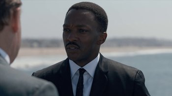 Movie still from “All the Way” (2016), directed by Jay Roach – A man wearing a suit and tie standing in front of a body of water; Close Up shot, Over the shoulder angle