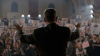 Movie still from “All the Way” (2016), directed by Jay Roach – A man is standing in front of a group of people; Wide shot, High angle