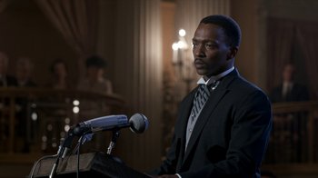 Movie still from “All the Way” (2016), directed by Jay Roach – A man standing at a podium with a microphone in front of him; Close Up shot, Over the shoulder angle