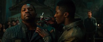 Movie still from “Allegiant” (2016), directed by Robert Schwentke – A man holding a spray gun in front of another man's face; Close Up shot, Over the shoulder angle