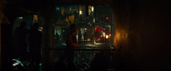 Movie still from “Allegiant” (2016), directed by Robert Schwentke – A woman standing in front of a crowd of people at a bar; Wide shot, Low angle