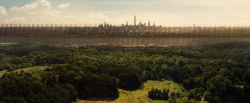 Movie still from “Allegiant” (2016), directed by Robert Schwentke – An aerial view of a large city with trees in the foreground; Extreme Wide shot, Low angle
