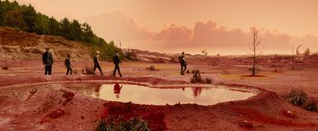 Movie still from “Allegiant” (2016), directed by Robert Schwentke – A group of people walking across a muddy field; Extreme Wide shot, High angle