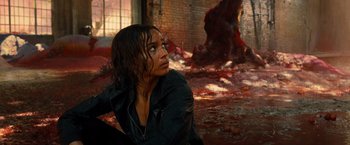 Movie still from “Allegiant” (2016), directed by Robert Schwentke – A woman sitting on the ground in a room; Medium shot, High angle