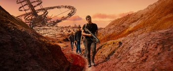 Movie still from “Allegiant” (2016), directed by Robert Schwentke – A group of people walking on a dirt path; Wide shot, High angle