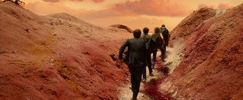 Movie still from “Allegiant” (2016), directed by Robert Schwentke – A group of people walking on a dirt path; Wide shot, High angle