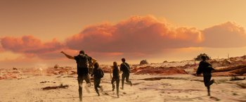 Movie still from “Allegiant” (2016), directed by Robert Schwentke – A group of people running across a snow covered field; Wide shot, High angle