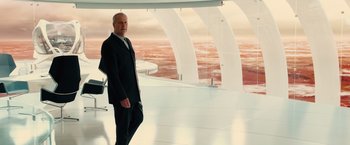 Movie still from “Allegiant” (2016), directed by Robert Schwentke – A man in a suit standing in front of an ocean; Wide shot, High angle