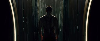 Movie still from “Allegiant” (2016), directed by Robert Schwentke – A man standing in the rain with his back to the camera; Medium shot, Low angle