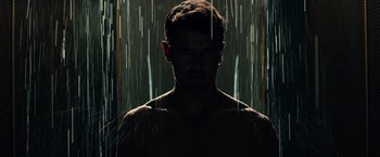 Movie still from “Allegiant” (2016), directed by Robert Schwentke – A man standing in the rain under a shower curtain; Close Up shot, Low angle