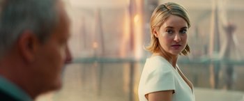 Movie still from “Allegiant” (2016), directed by Robert Schwentke – A woman in a white dress is standing in a room; Close Up shot, Over the shoulder angle