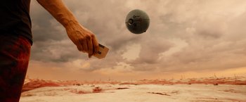 Movie still from “Allegiant” (2016), directed by Robert Schwentke – A hand is holding a piece of wood while a ball is flying in the air; Extreme Wide shot, Low angle