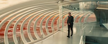 Movie still from “Allegiant” (2016), directed by Robert Schwentke – A man standing in front of a large glass wall; Wide shot, High angle