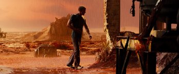 Movie still from “Allegiant” (2016), directed by Robert Schwentke – A man standing on a skateboard in the middle of an area; Wide shot, High angle