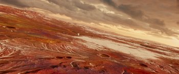 Movie still from “Allegiant” (2016), directed by Robert Schwentke – An aerial view of a desert landscape under a cloudy sky; Extreme Wide shot, Overhead angle