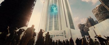 Movie still from “Allegiant” (2016), directed by Robert Schwentke – A group of people standing in front of a tall building; Extreme Wide shot, Low angle