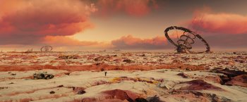 Movie still from “Allegiant” (2016), directed by Robert Schwentke – A man flying a kite on a rocky beach; Extreme Wide shot, High angle