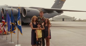 Movie still from “Aloha” (2015), directed by Cameron Crowe – A man and two women and a boy standing in front of an airplane; Wide shot, Low angle