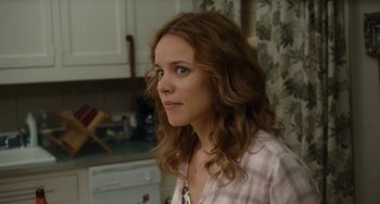 Movie still from “Aloha” (2015), directed by Cameron Crowe – A woman in a plaid shirt is standing in a kitchen; Close Up shot, Over the shoulder angle