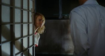 Movie still from “Aloha” (2015), directed by Cameron Crowe – A woman looking out a window at a man; Medium shot, Over the shoulder angle