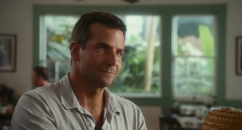 Movie still from “Aloha” (2015), directed by Cameron Crowe – A person sitting in a room near a window; Close Up shot, Over the shoulder angle