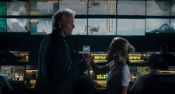 Movie still from “Aloha” (2015), directed by Cameron Crowe – A man and a woman holding a glass of water; Medium shot, Over the shoulder angle
