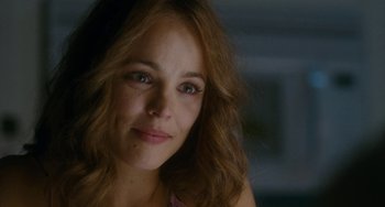 Movie still from “Aloha” (2015), directed by Cameron Crowe – A woman's face in a dark room; Close Up shot, Over the shoulder angle