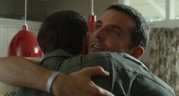 Movie still from “Aloha” (2015), directed by Cameron Crowe – A man hugging another man with his arm around another man; Close Up shot, Over the shoulder angle