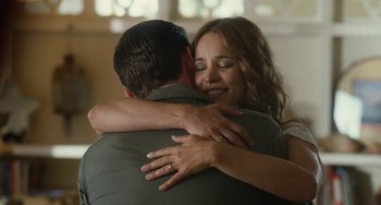 Movie still from “Aloha” (2015), directed by Cameron Crowe – A man and a woman hugging each other in front of a window; Close Up shot, Over the shoulder angle