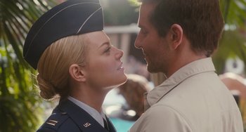 Movie still from “Aloha” (2015), directed by Cameron Crowe – A man and a woman in military uniforms kissing each other; Close Up shot, Over the shoulder angle