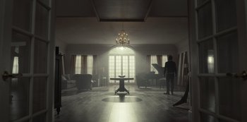 Movie still from “Fargo” (2014), created by Noah Hawley – A person standing in a room with a piano; Extreme Wide shot, High angle