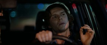 Movie still from “American Animals” (2018), directed by Bart Layton – A man driving a car in the dark; Close Up shot, Low angle