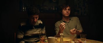 Movie still from “American Animals” (2018), directed by Bart Layton – Two young men sitting at a dinner table eating; Medium shot, Over the shoulder angle
