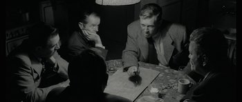 Movie still from “American Animals” (2018), directed by Bart Layton – A group of men sitting at a table with papers; Medium shot, Over the shoulder angle