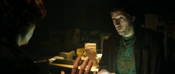 Movie still from “American Animals” (2018), directed by Bart Layton – A man sitting in front of a computer in a dark room; Medium shot, Over the shoulder angle