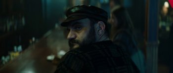 Movie still from “American Animals” (2018), directed by Bart Layton – A man with a beard wearing a black hat; Close Up shot, Over the shoulder angle